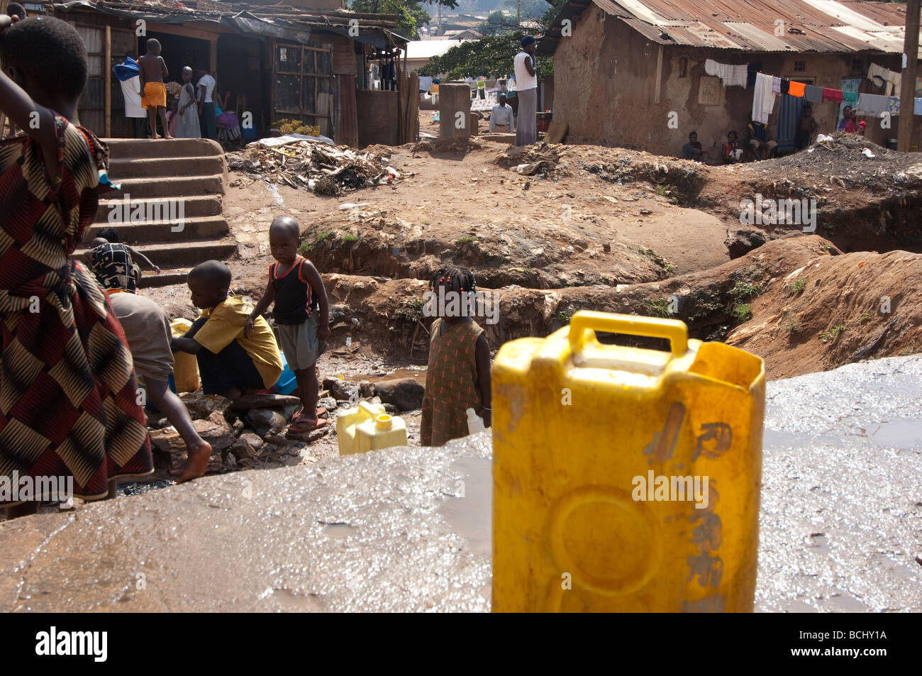 Les enfants vont chercher de l'eau contaminés de printemps. Kamwockya Kampala Ouganda Banque D'Images