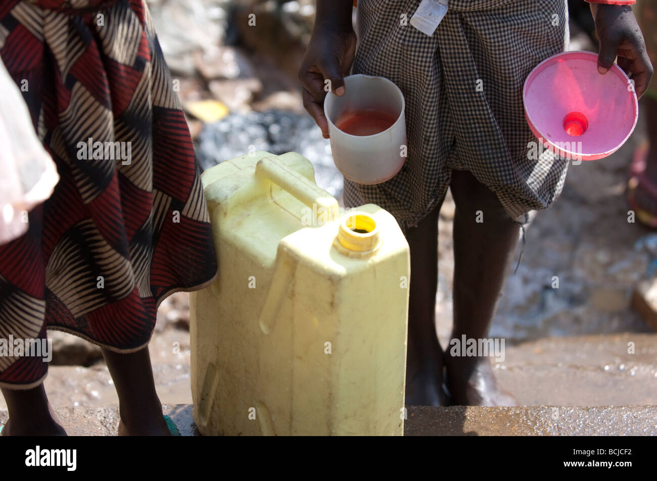 Les enfants vont chercher de l'eau contaminés de printemps. Kamwockya Kampala Ouganda Banque D'Images