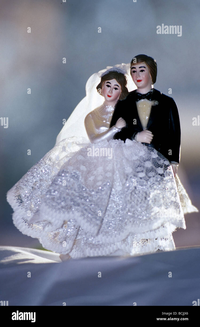 Métaphore de mariage heureux : Cake toppers Bride and Groom figurines standing proche, elle est tenue de lui. Banque D'Images