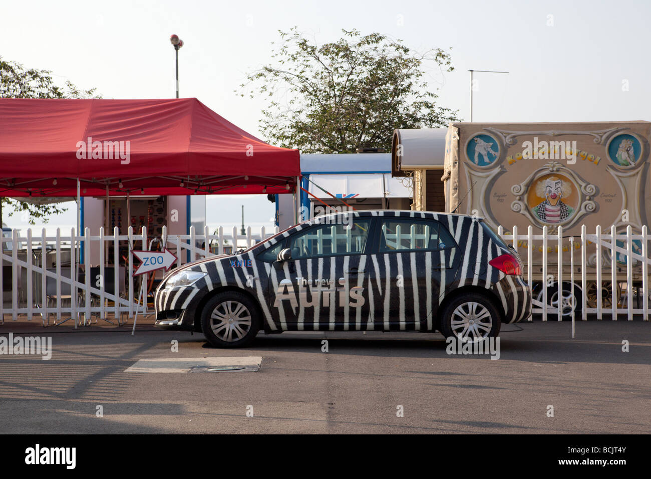 Voiture de cirque peint avec zebra stripes contre une clôture. Charles Lupica Banque D'Images