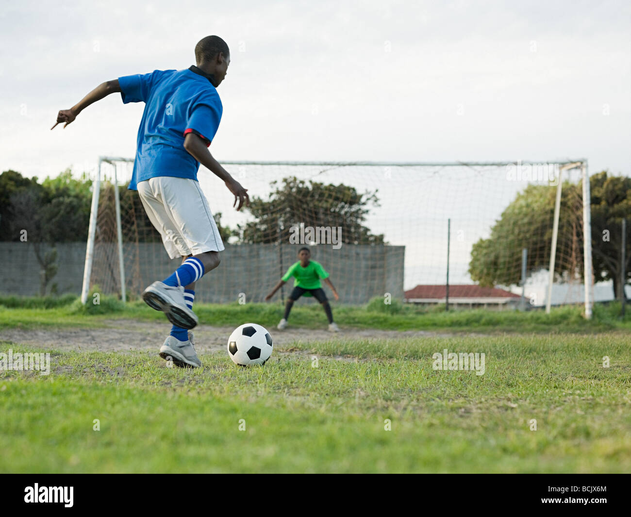 Garçons jouant au football Banque D'Images