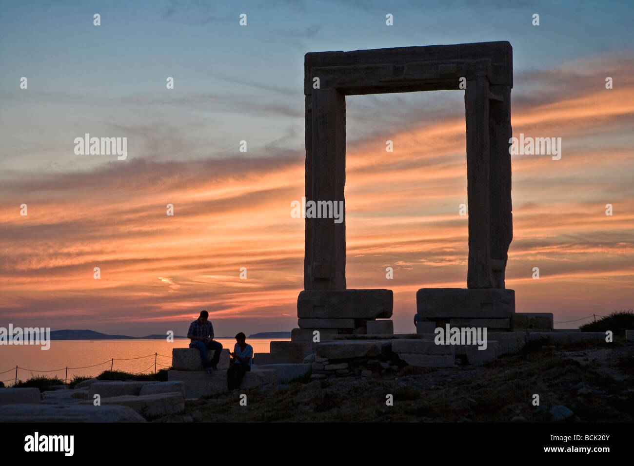 Ruines de la porte du temple d'Apollon appelé Portara sur l'île de Naxos Grèce Couple en silhouette au coucher du soleil Banque D'Images