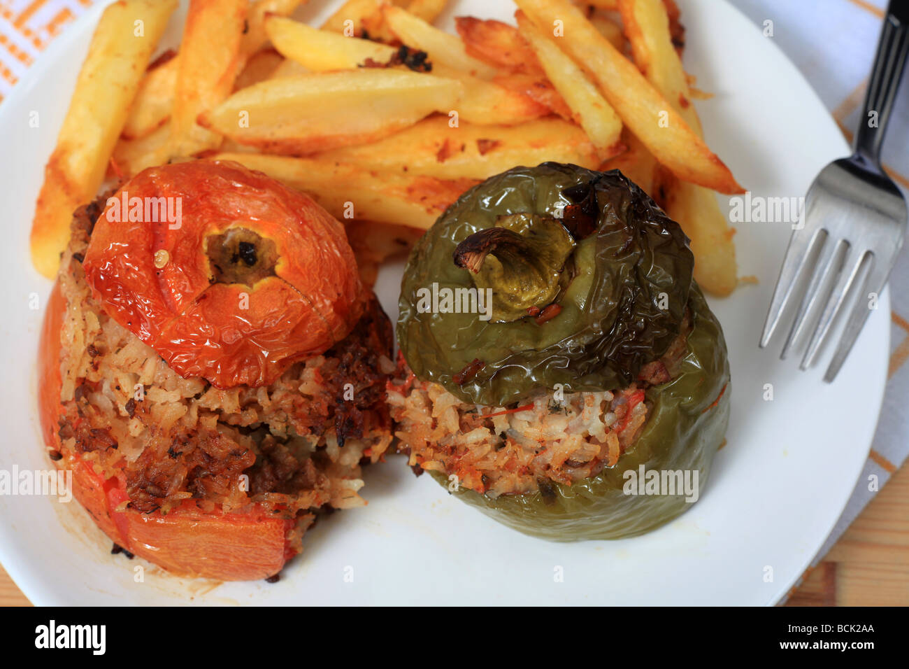 Les légumes farcis dans le style grec, rempli avec de la viande et du riz et servi avec des chips de pomme de terre frites Banque D'Images