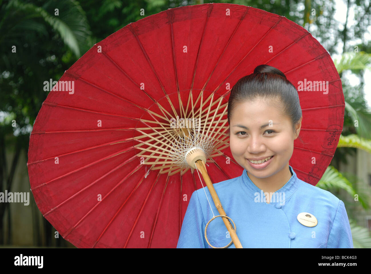 Mandarin Oriental Dhara Dhevi, Chiang Mai 5 étoiles luxe hôtel Thai dame au parapluie parasol parasol accueil souriant Banque D'Images