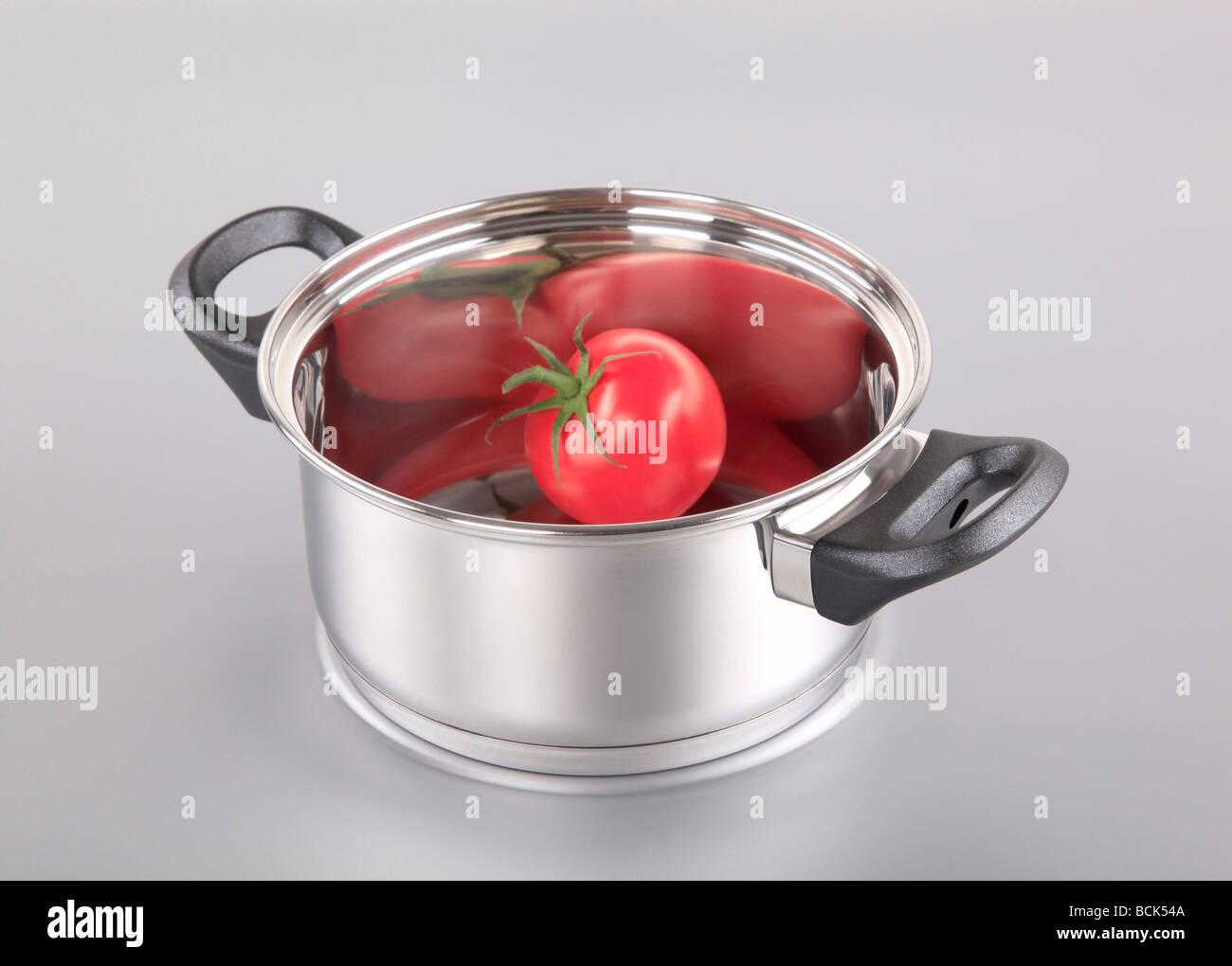 Tomate rouge dans un pot en acier inoxydable Banque D'Images