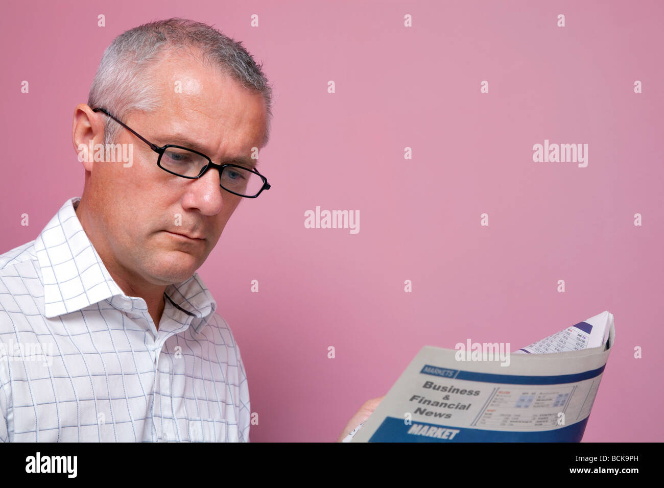 Businessman reading les derniers prix des actions dans un journal financier Banque D'Images
