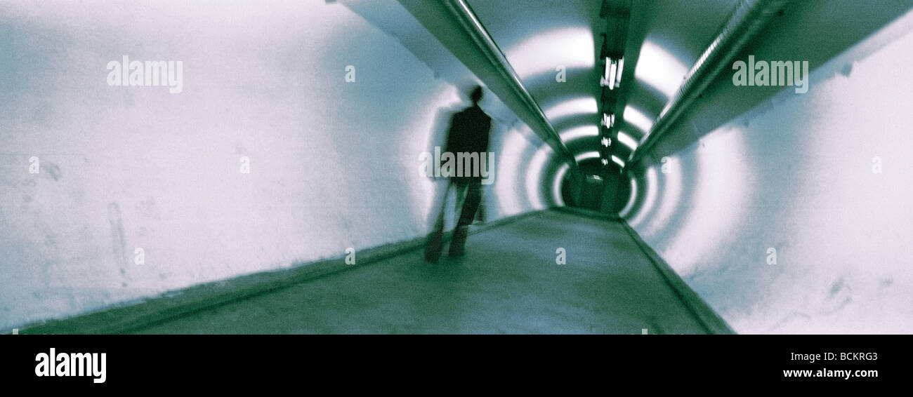 Homme marchant dans un passage souterrain, vue panoramique Banque D'Images
