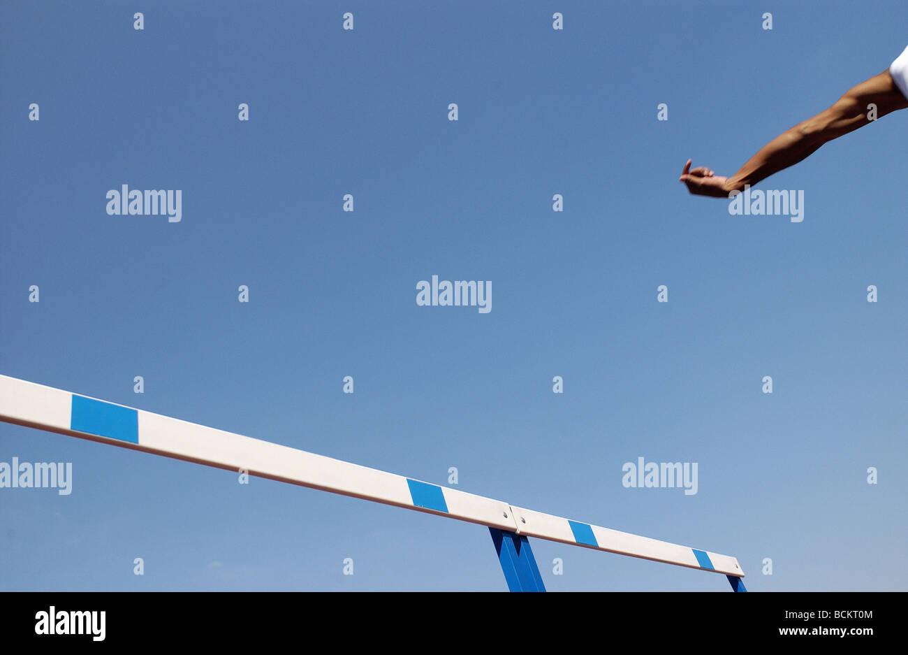 Le bras de l'athlète et l'obstacle contre le ciel bleu Banque D'Images