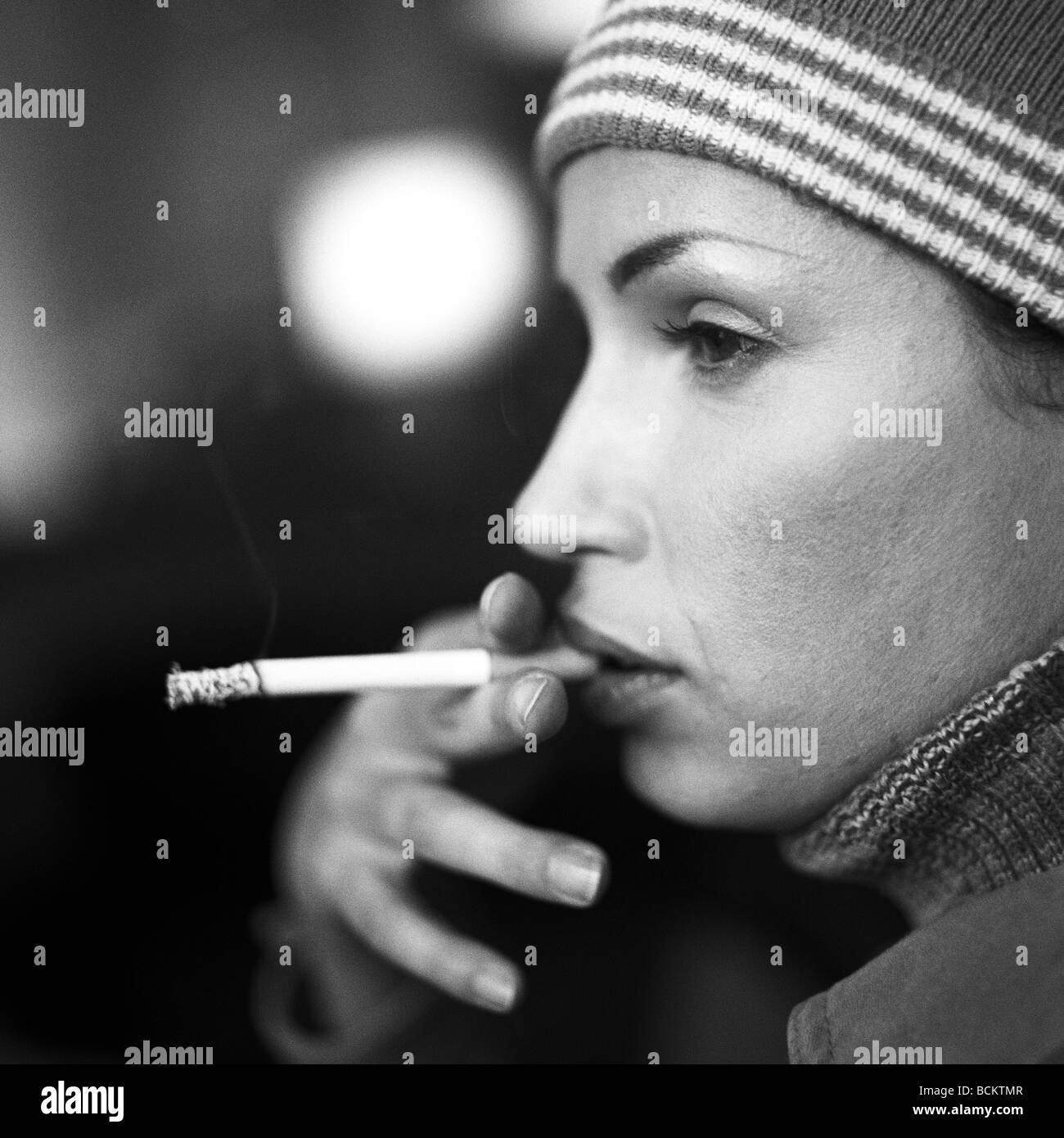 Femme fumant, side view Banque D'Images