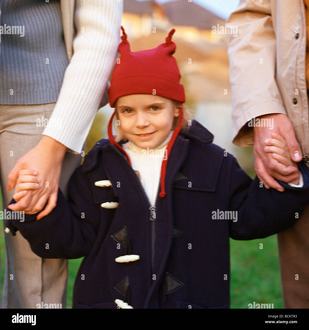 Little girl holding hands des parents Banque D'Images
