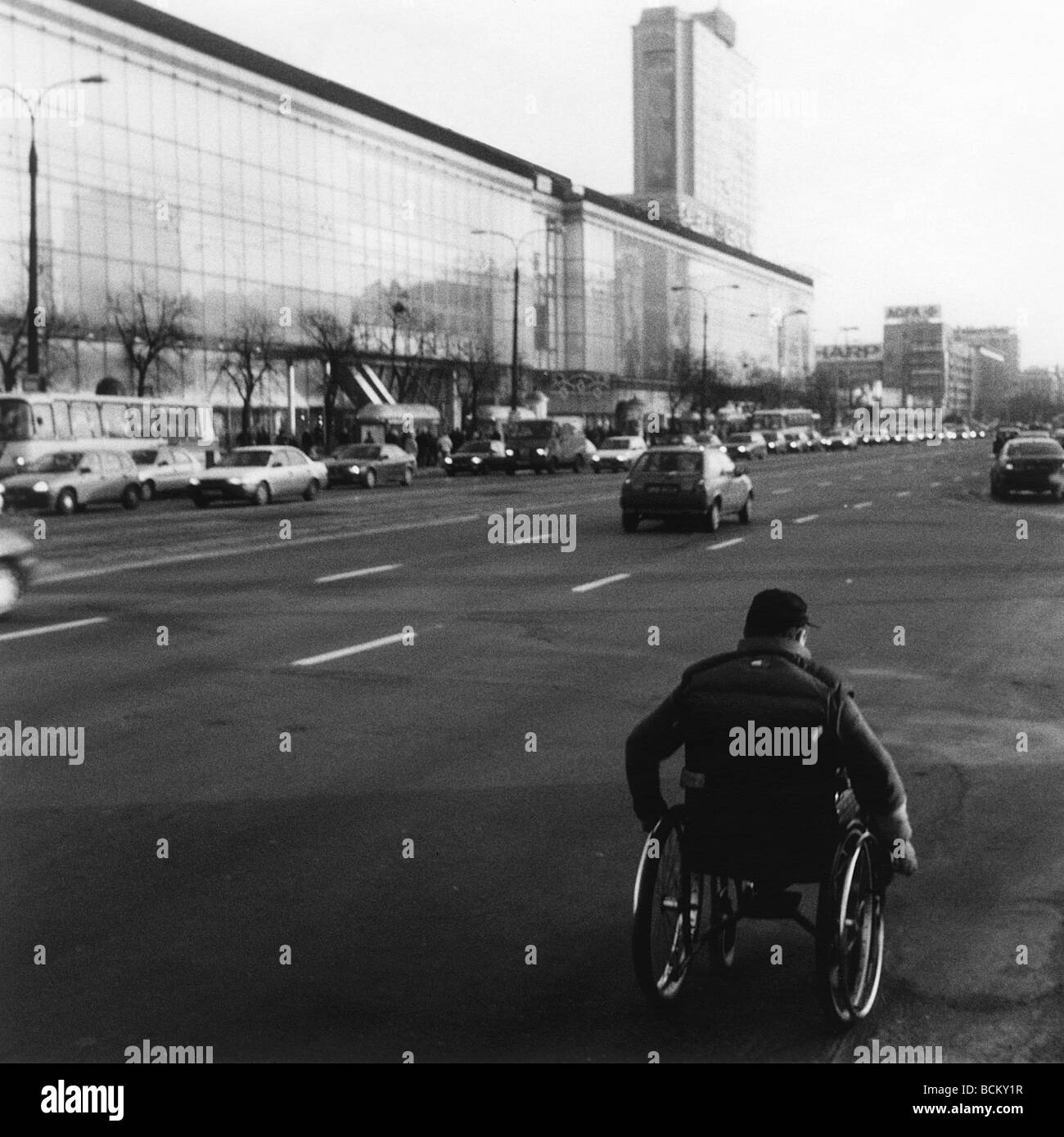 L'homme en fauteuil roulant sur route, b&w Banque D'Images