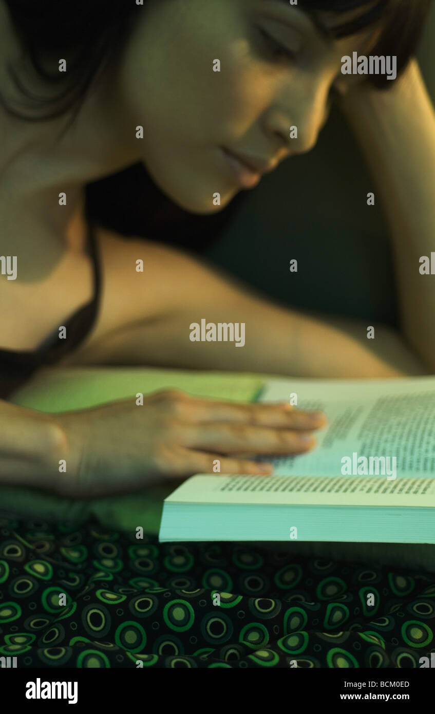 Femme couchée sur le côté, reading book, close-up Banque D'Images