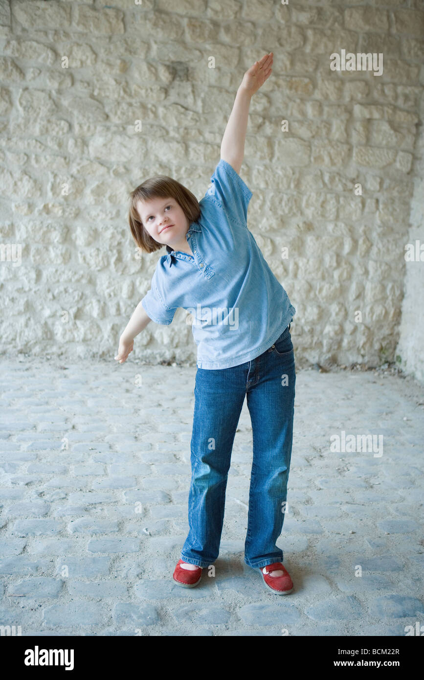 Fille avec le syndrome de standing with arms raised, prétendant être un avion Banque D'Images