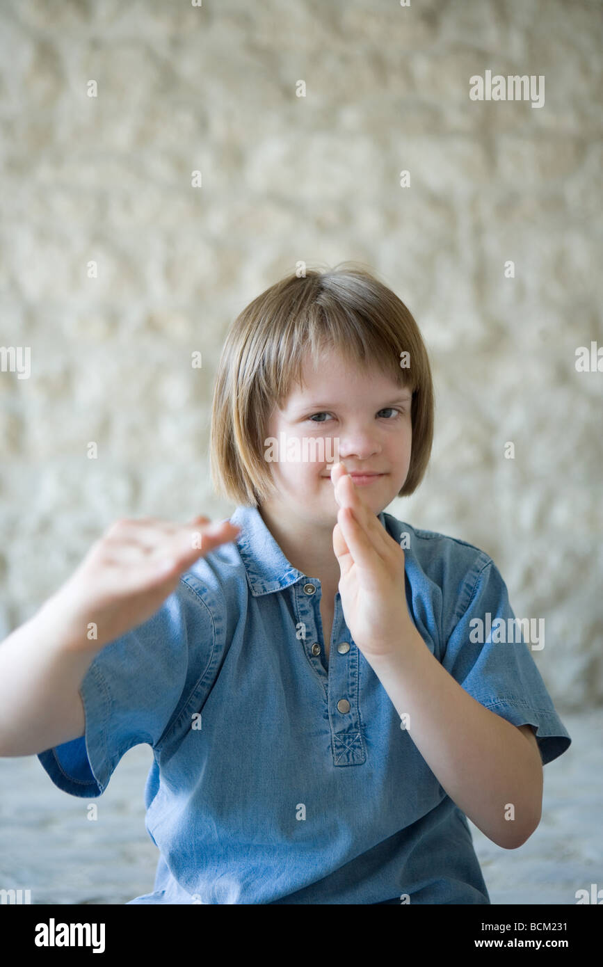 Fille avec le syndrome de Down dans les arts martiaux, bras levés, smiling at camera, portrait Banque D'Images