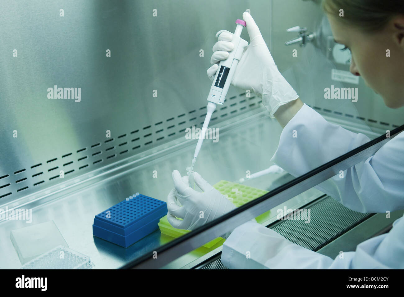 Female scientist dragées tube à essai en laboratoire, side view Banque D'Images