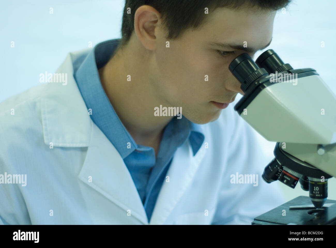 Male scientist looking through microscope, close-up Banque D'Images