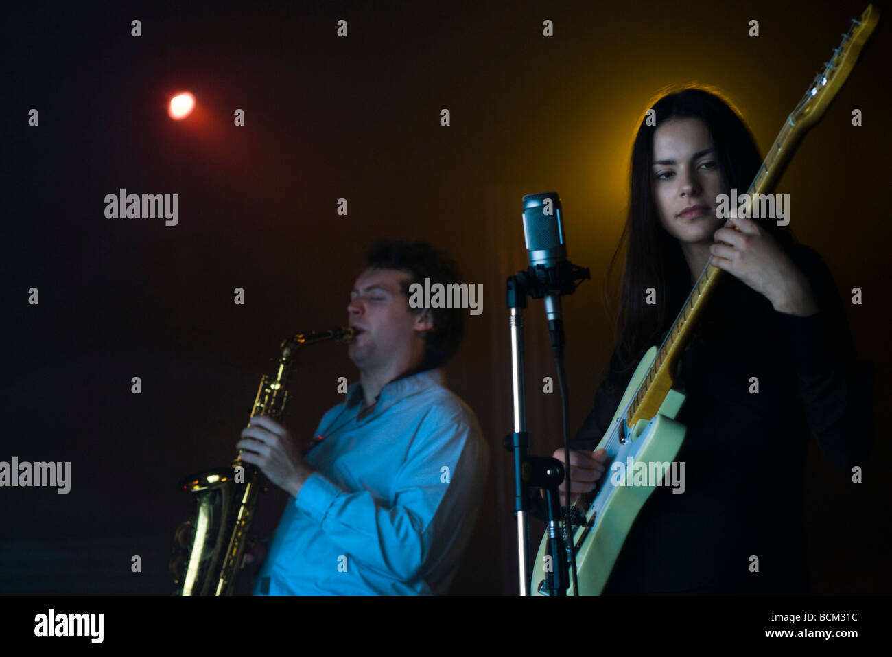 De jeunes musiciens jouant une guitare électrique et le saxophone dans night club Banque D'Images