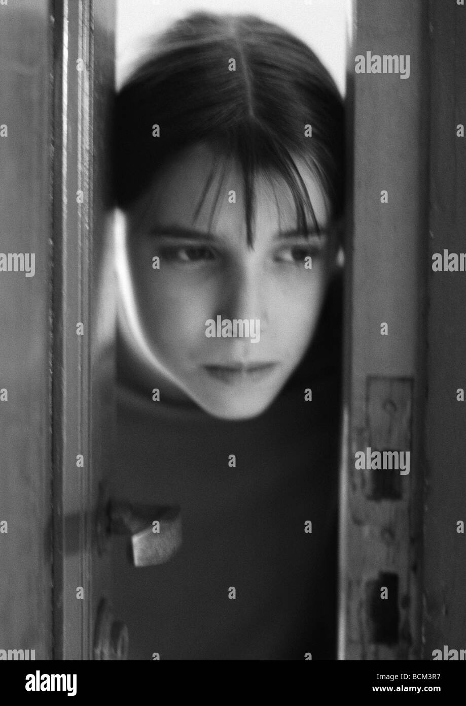 Girl looking through doorway Banque D'Images