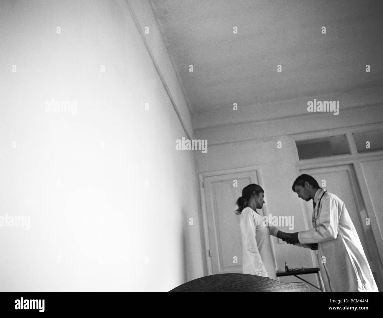 Doctor examining patient's arm, low angle view, inclinaison Banque D'Images