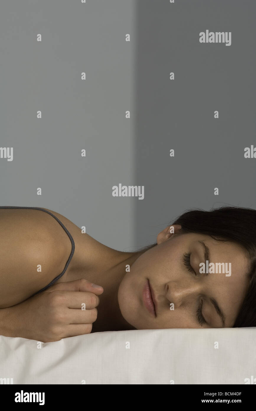 Femme couchée sur le matelas, les yeux clos, close-up Banque D'Images