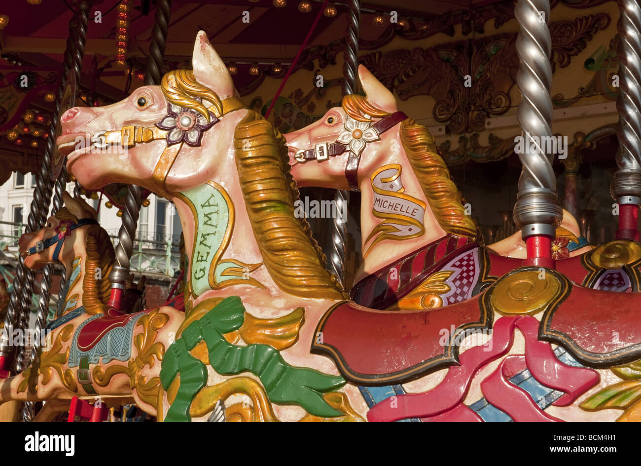 Près de deux chevaux de carrousel peint de couleurs vives sur les rond-point fête foraine manège à des expositions. Banque D'Images
