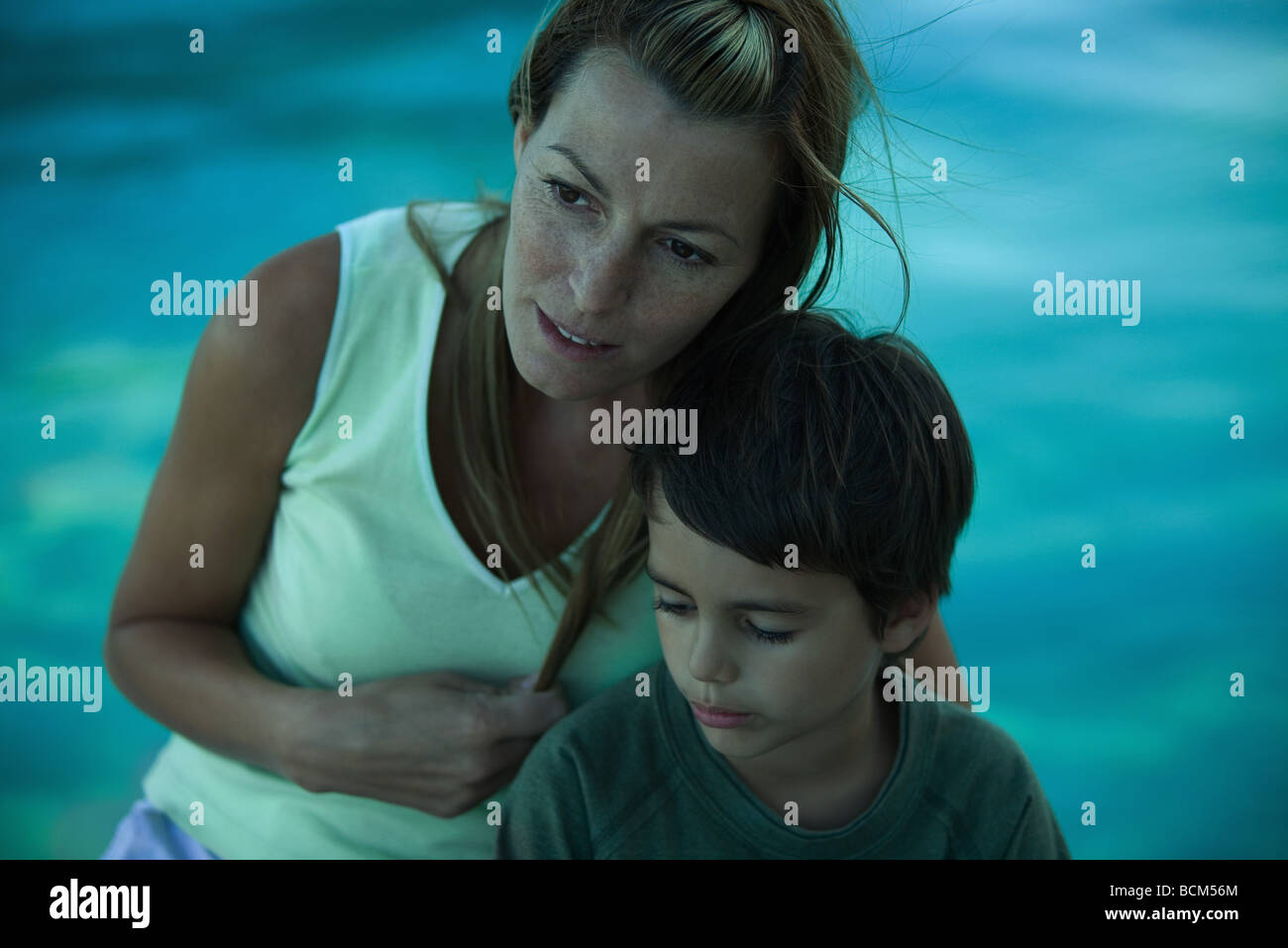 Mère assise avec fils près du bord de l'eau Banque D'Images