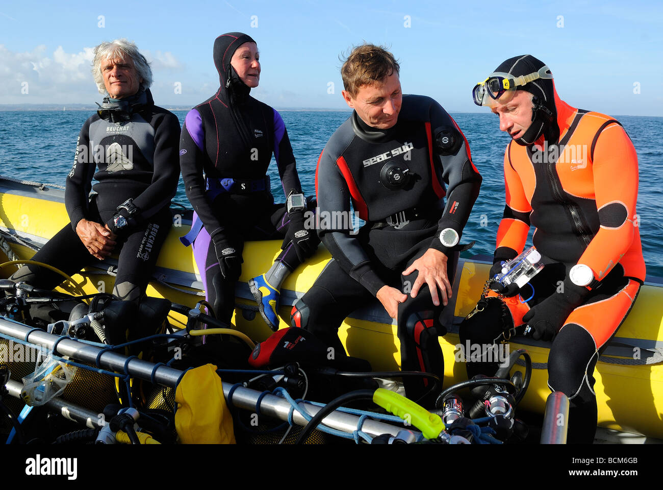 Les plongeurs assis dans un bateau gonflable en Bretagne Banque D'Images
