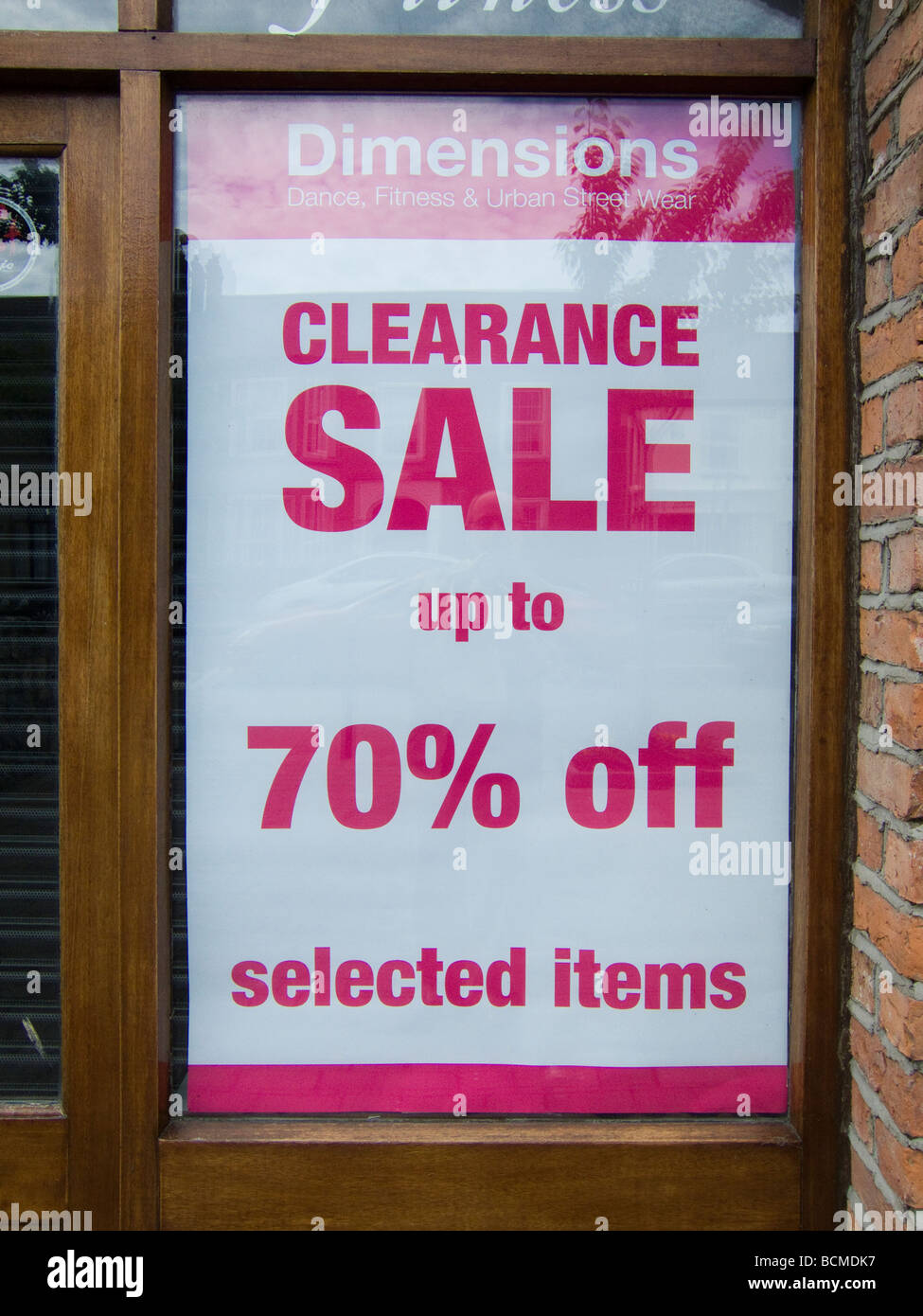 Une affiche dans la fenêtre d'un magasin de vêtements offrant des réductions massives en raison de la récession 2009 Irlande Dublin Banque D'Images