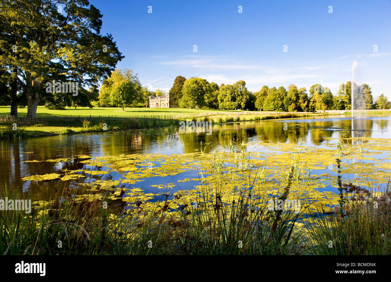 Le lac et la fontaine restaurée au parc Lydiard, Swindon, Wiltshire, Royaume-Uni Lydiard House avec en arrière-plan. Banque D'Images