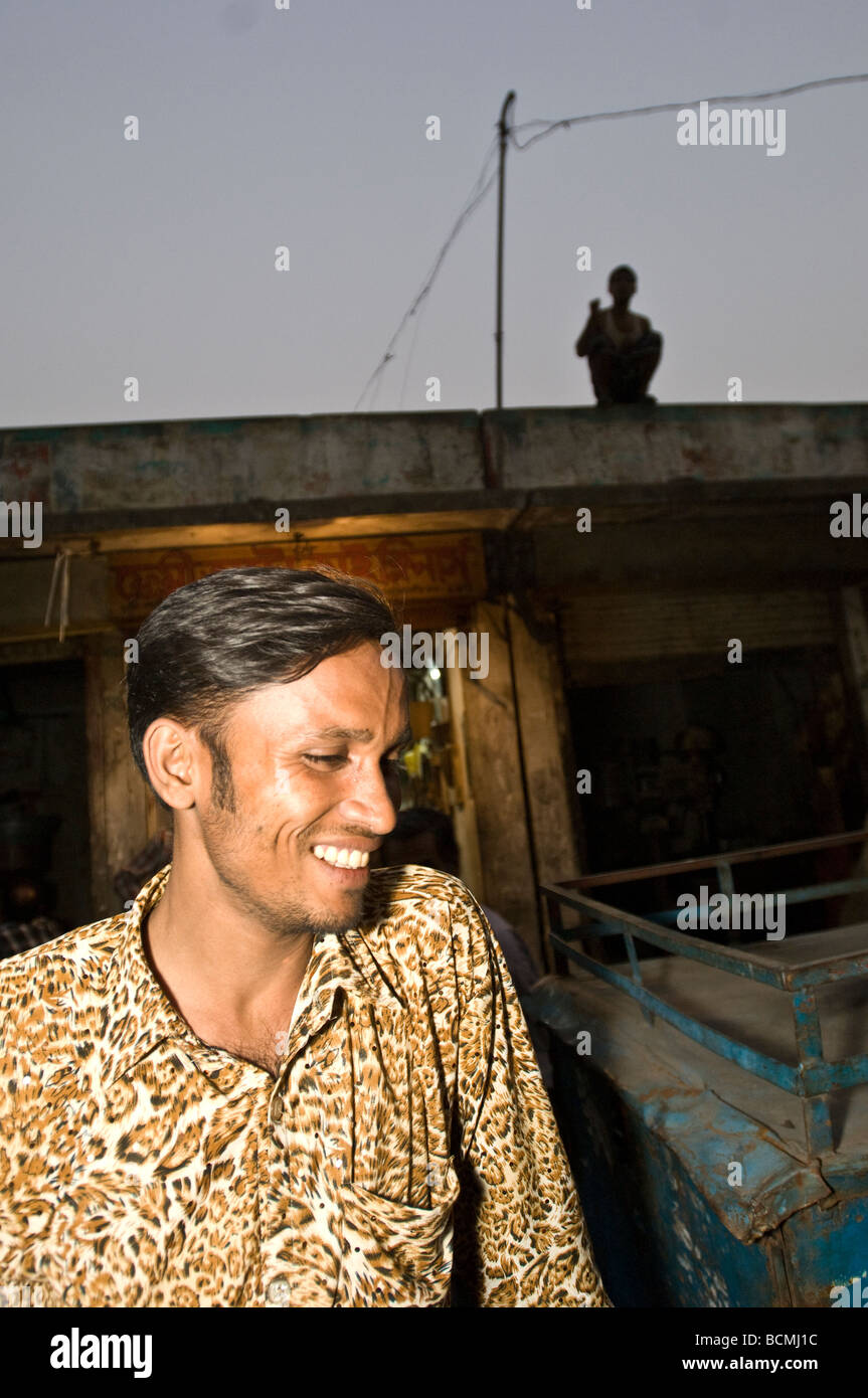 Dans l'homme leopard print shirt sur street à Dhaka Bangladesh avec sihouette du garçon sur le toit derrière Banque D'Images