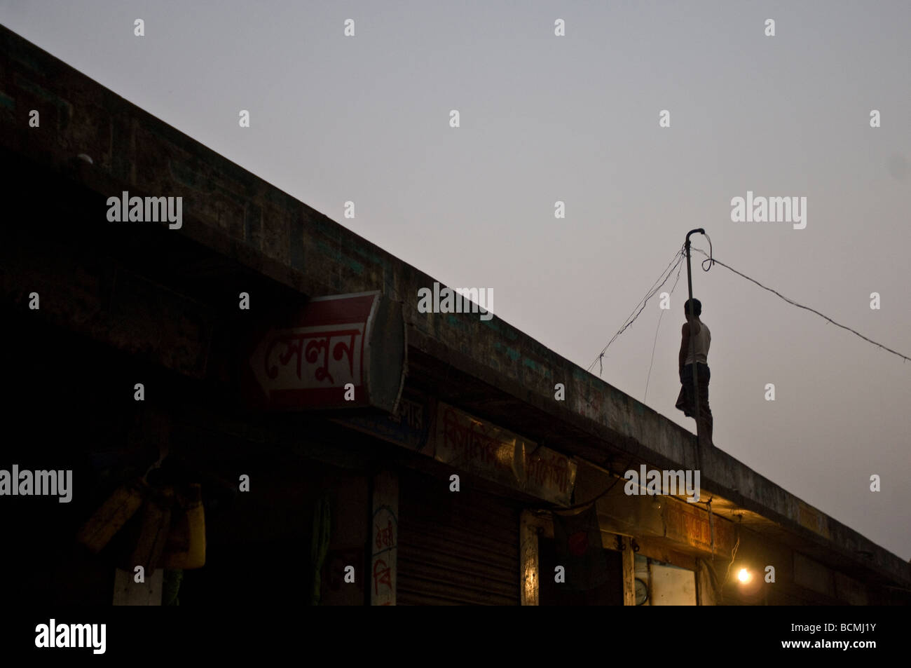 Homme debout sur le toit la nuit à Dhaka Bangladesh Banque D'Images
