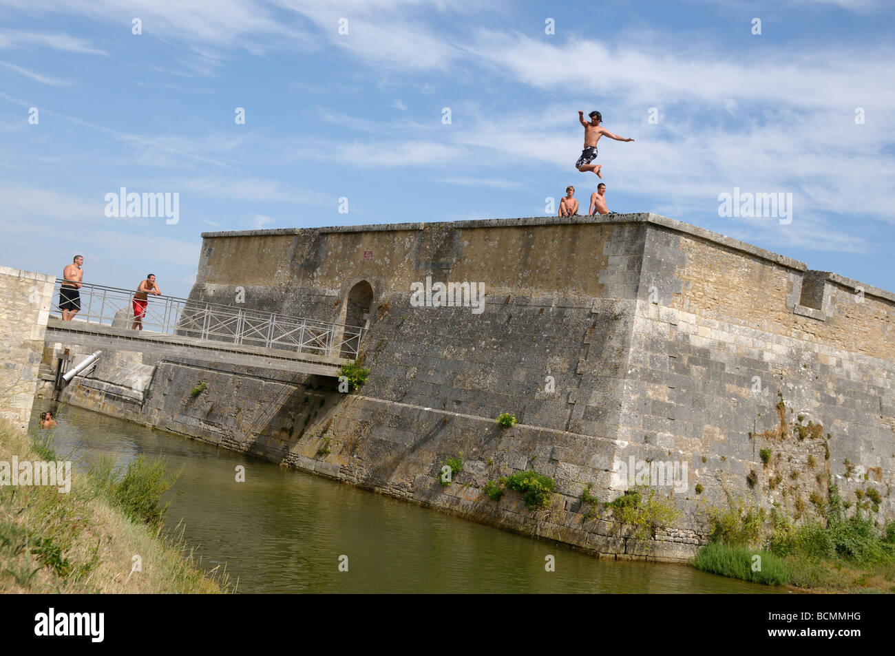 Stock photo des garçons en sautant des remparts de la ville, sur l'île d'Oléron en France et à l'atterrissage dans la mer bon plaisir ou ce que Banque D'Images