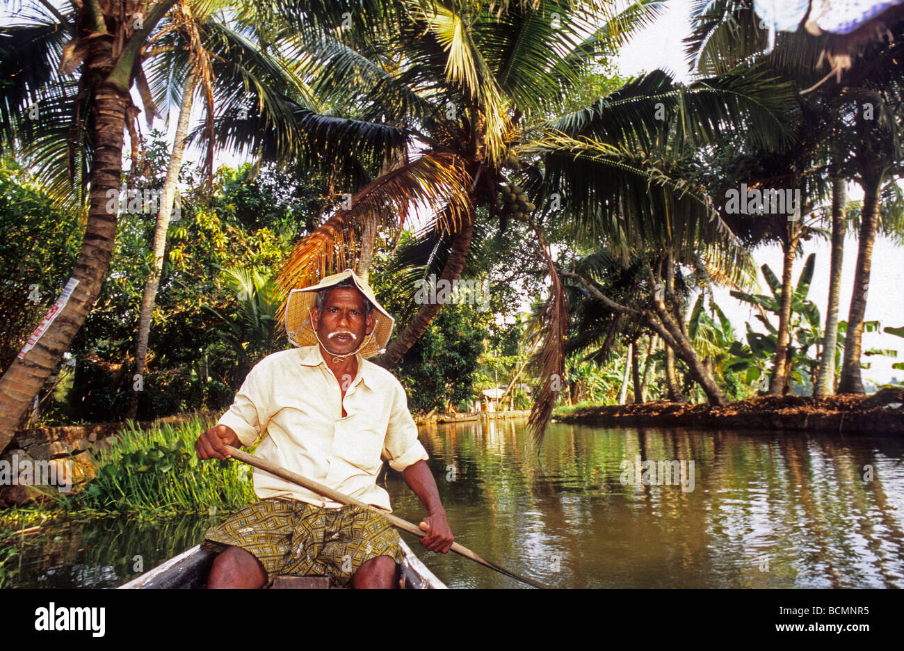 L'homme Petit bateau à rames sur Alleppey Backwaters Kerala Inde Banque D'Images