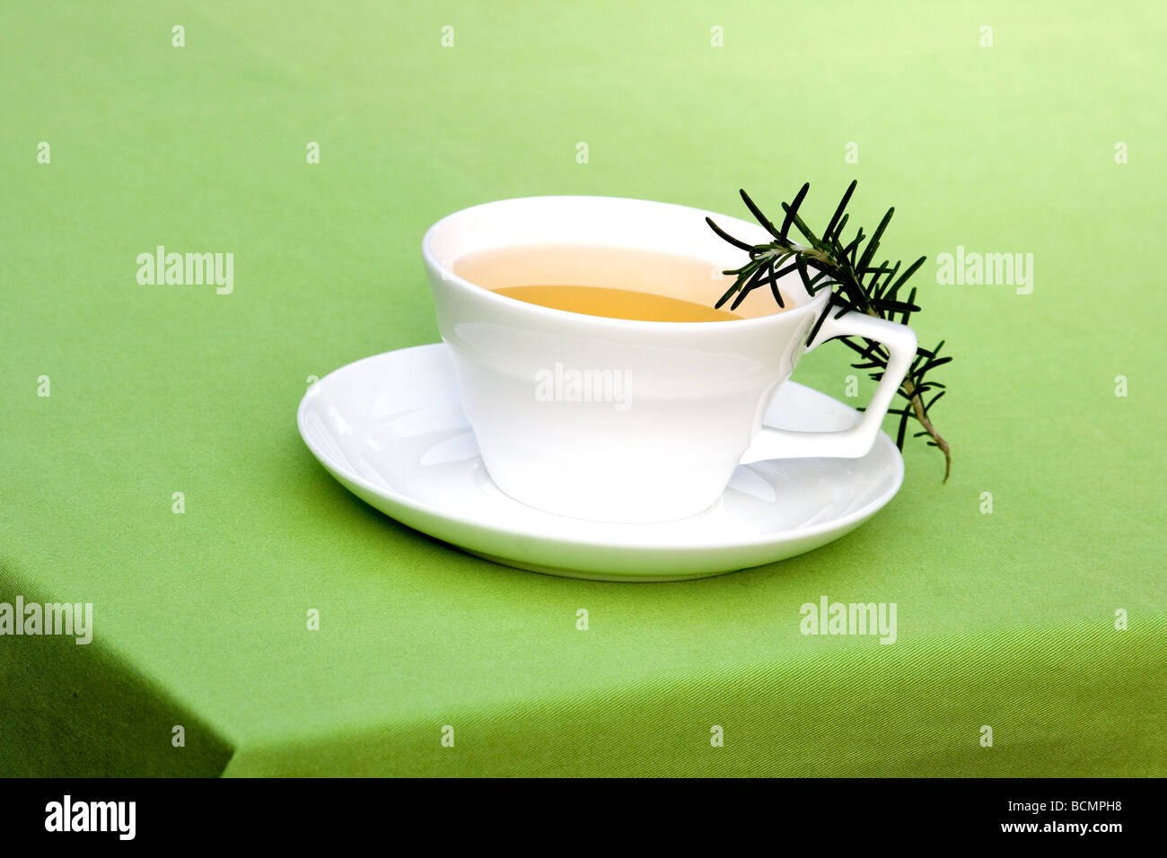 White tasse de tisane sur une nappe verte Banque D'Images