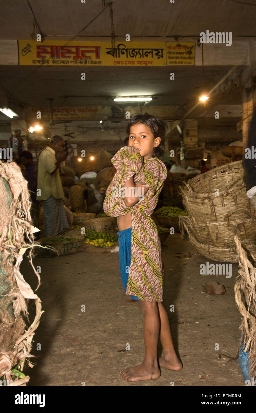 Enfant de la rue, la collecte de rebuts ou de voler de la nourriture dans le marché de nuit de Dhaka Bangladesh Banque D'Images