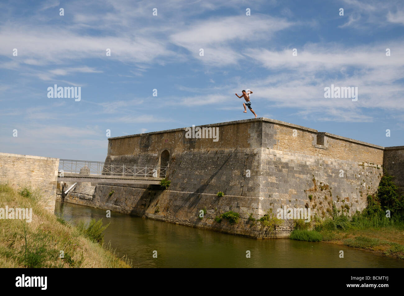 Stock photo des garçons en sautant des remparts de la ville sur l'île d'Oléron en France et à l'atterrissage dans la mer bon plaisir ou ce que Banque D'Images
