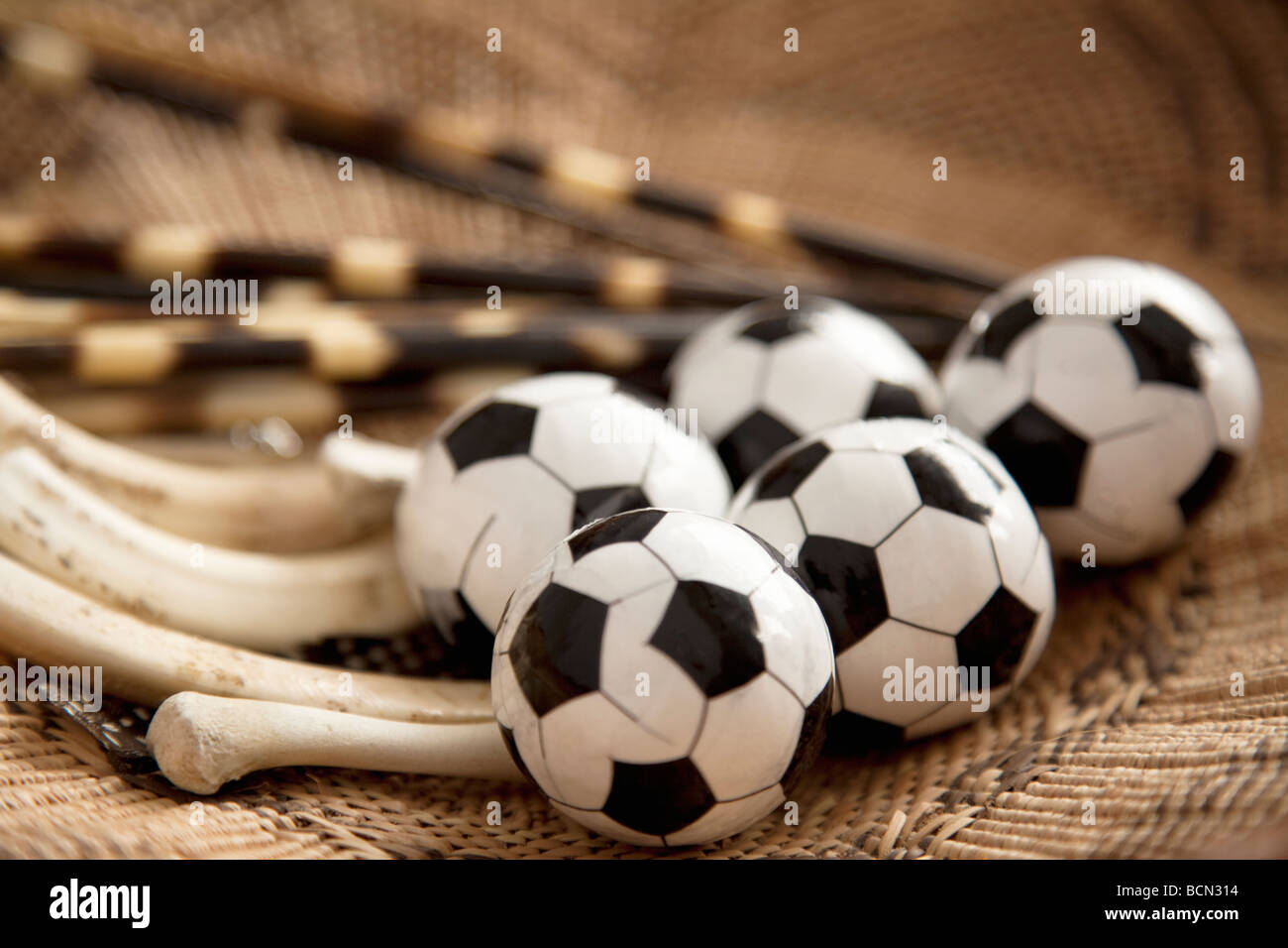 Les ballons de football miniature dans un panier d'herbe tressée avec des os d'animaux et de porc-épic Banque D'Images
