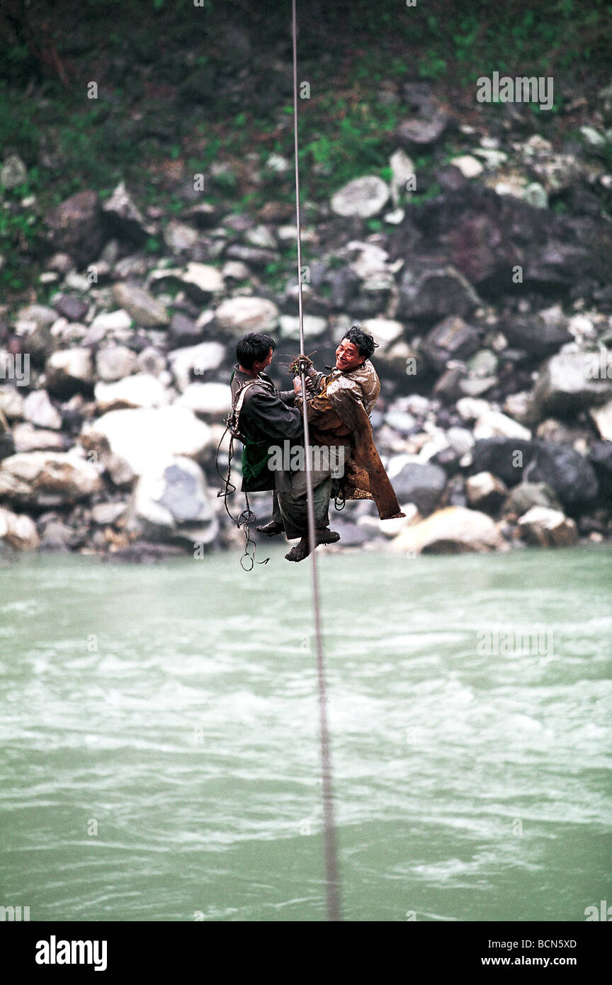 Les sections locales crossing river en utilisant la corde de suspension bridge, Bingzhongluo, Province du Yunnan, Chine Banque D'Images