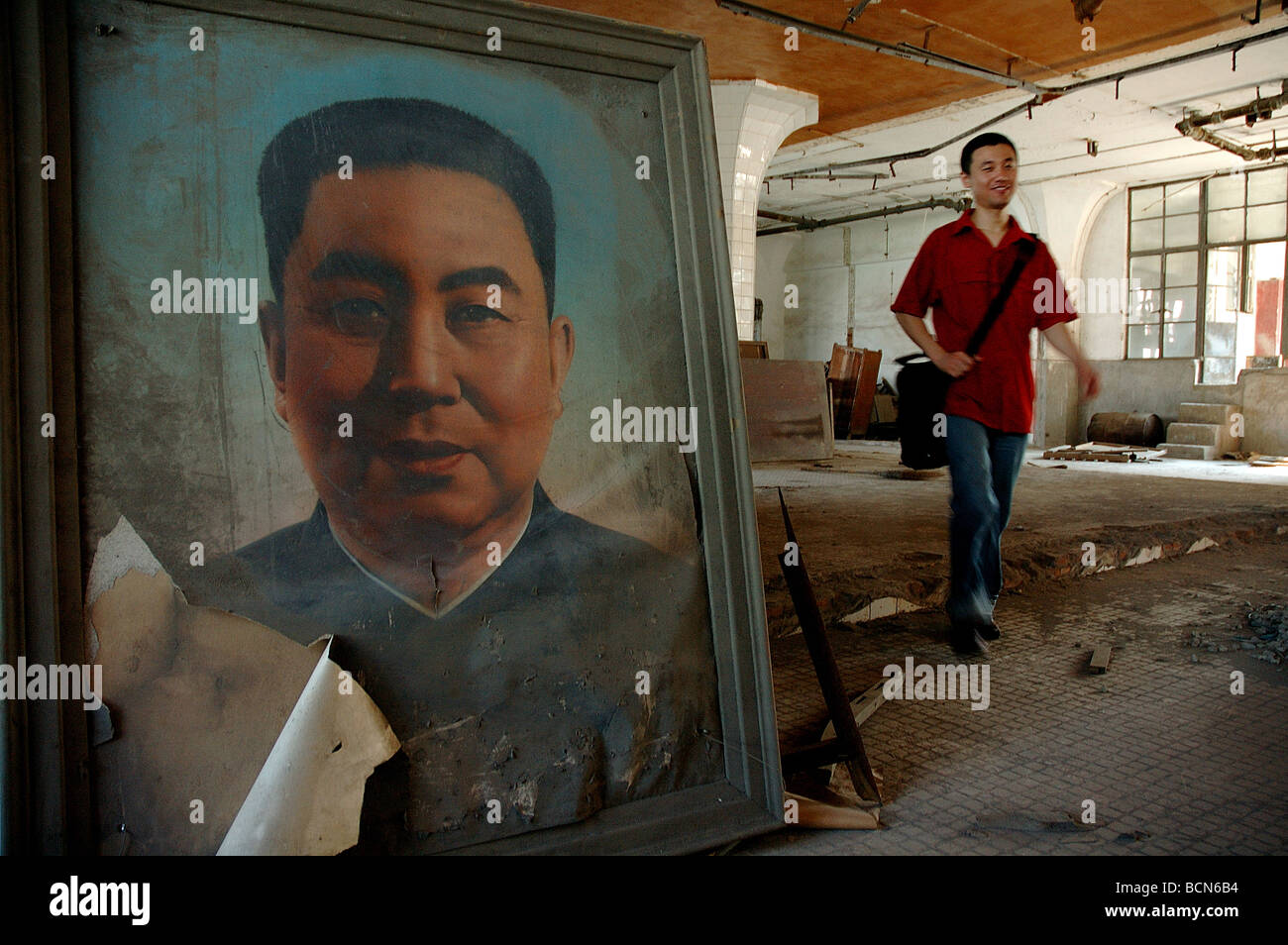 Jeune homme passe par le portrait poussiéreux de Hua Guofeng, Shanghai, Chine Banque D'Images