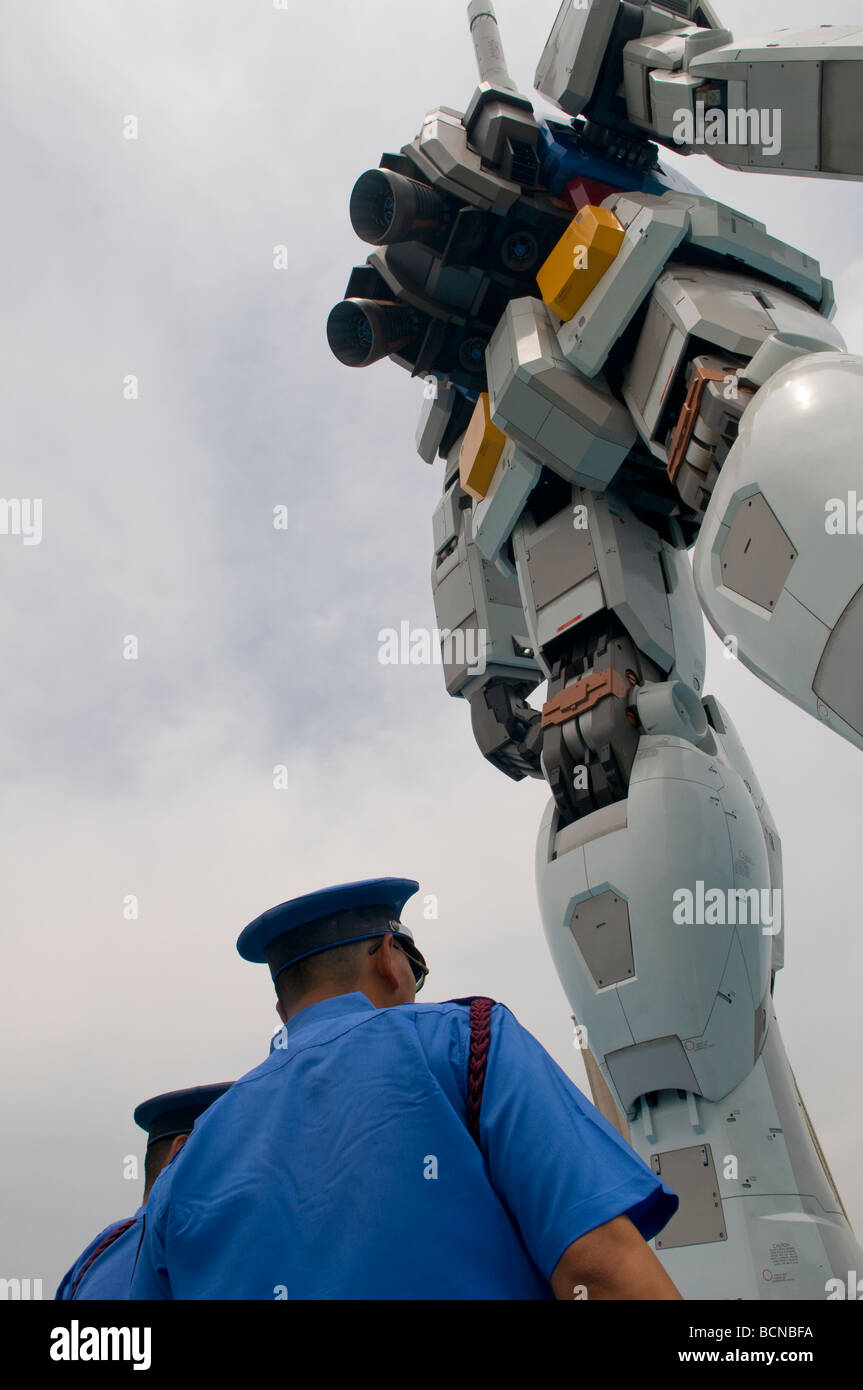 Les policiers se tiennent près de réplique géante de la science-fiction d'animation robot Gundam dans parc en bord de mer grande île artificielle d'Odaiba dans la baie de Tokyo, Japon Banque D'Images