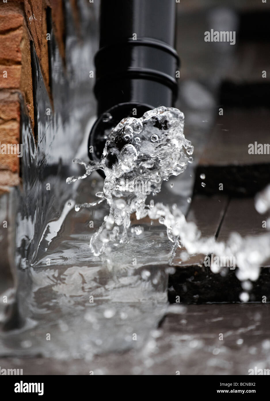 L'eau de pluie jaillissant d'une gouttière sur une maison dans le Worcestershire, Royaume-Uni Banque D'Images