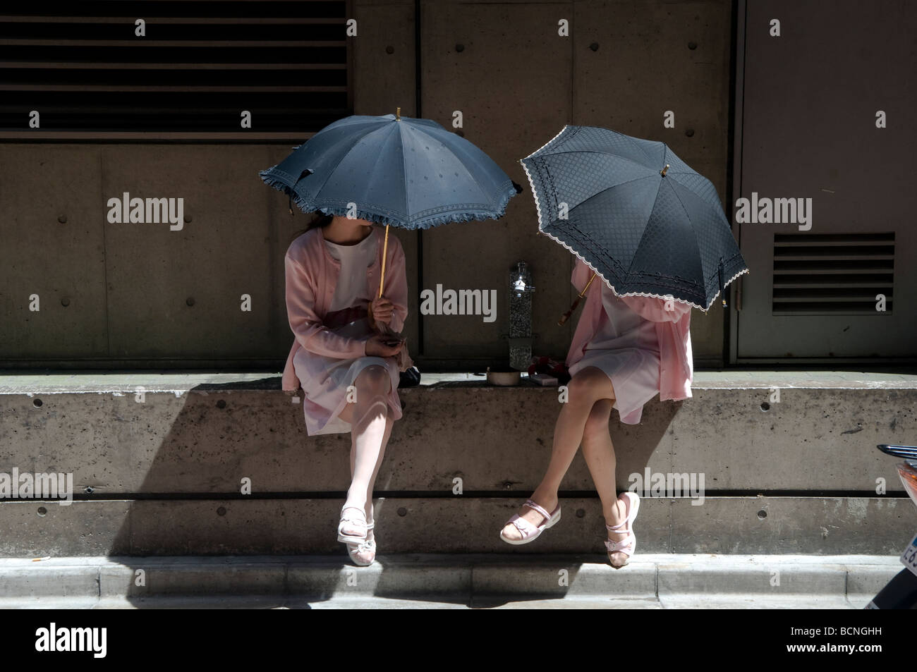 Femme japonaise de l'emplacement sous des parasols sur une journée ensoleillée dans quartier de Ginza Tokyo Japon Banque D'Images