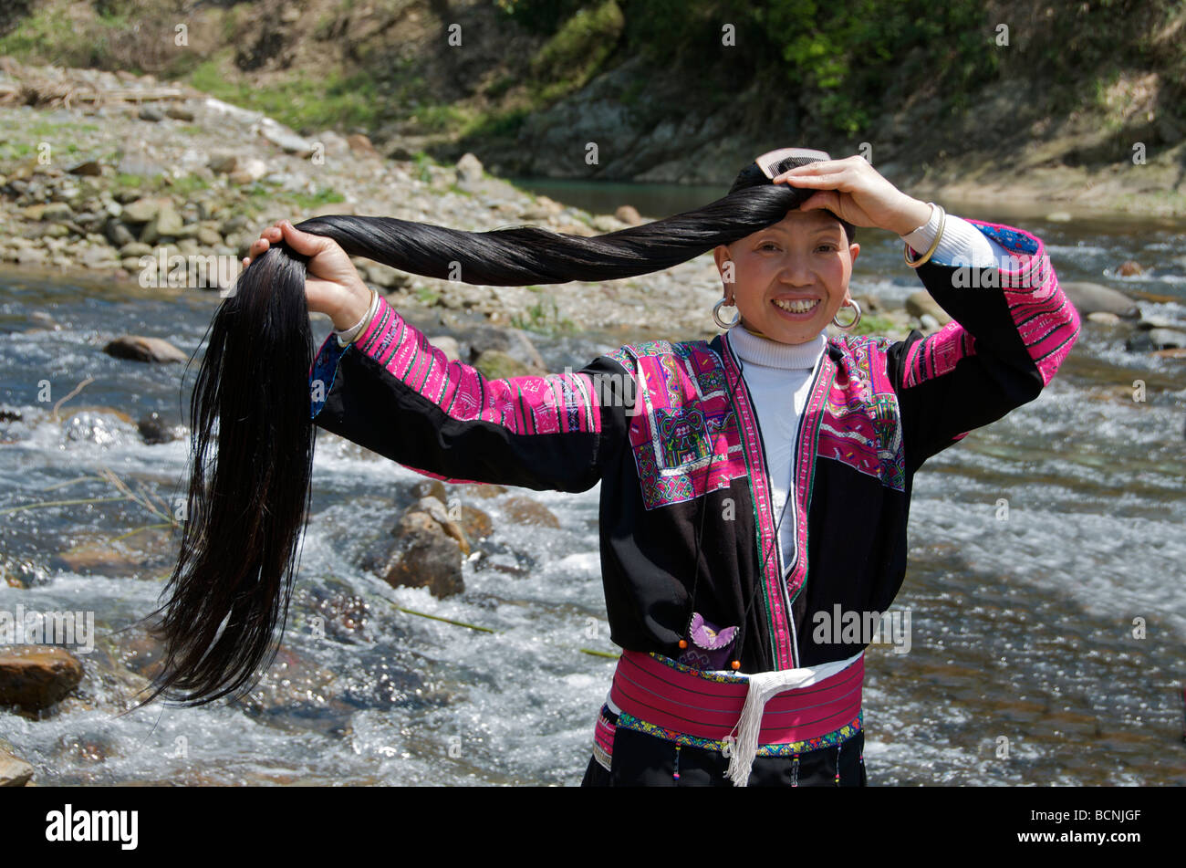 Yao Cheveux Longs femme peigner les cheveux à côté de River Village Huangluo Chine Guangxi Banque D'Images