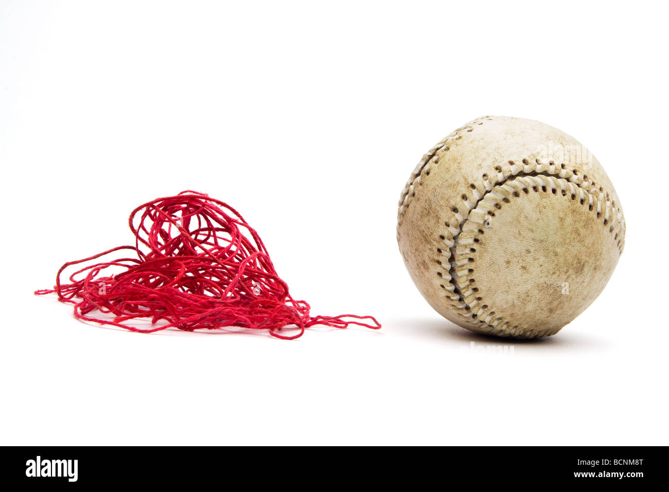 Baseball avec surpiqûres rouges vieux threads supprimés et dans une pile à côté de balle. Plafonniers vue frontale et isolé sur blanc. Banque D'Images