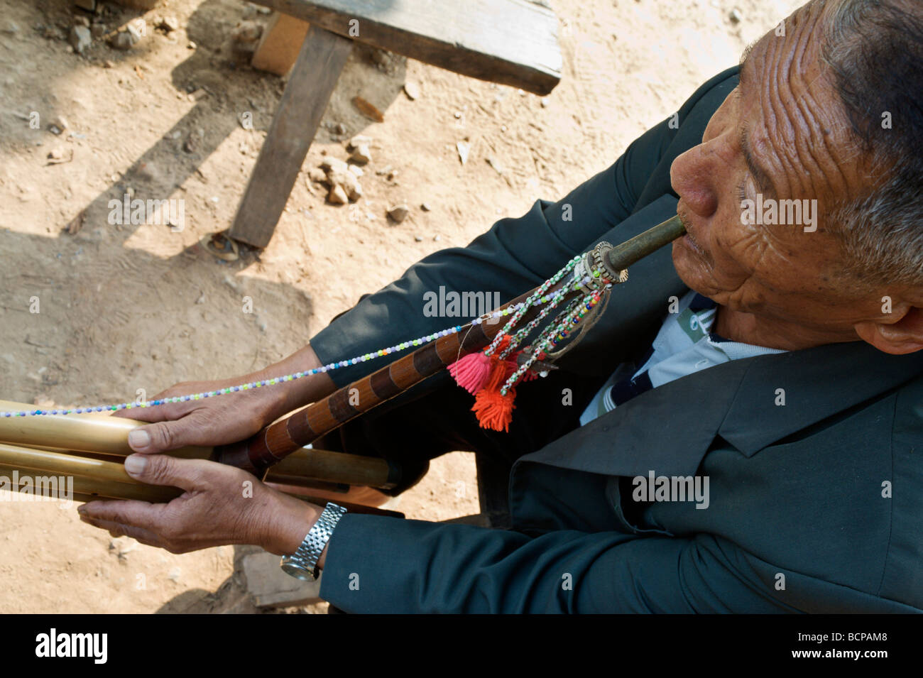 La tribu Hmong ancien homme jouant d'un instrument de bambou traditionnel dans un village dans le nord de la Thaïlande Banque D'Images