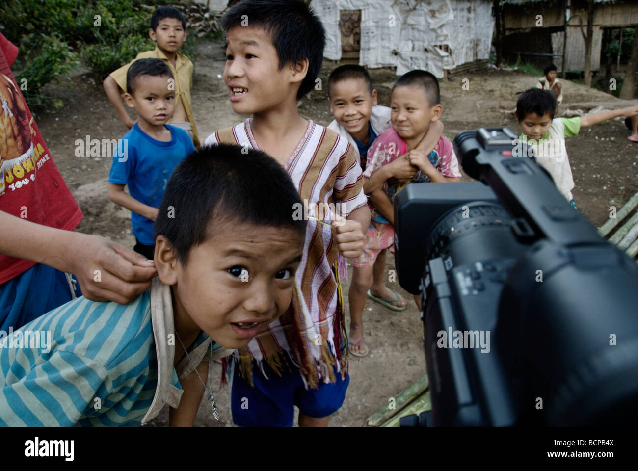 Enfants jouant et en regardant une caméra vidéo dans un camp de réfugiés sur la Thai Burma Border à Mae Lai Banque D'Images