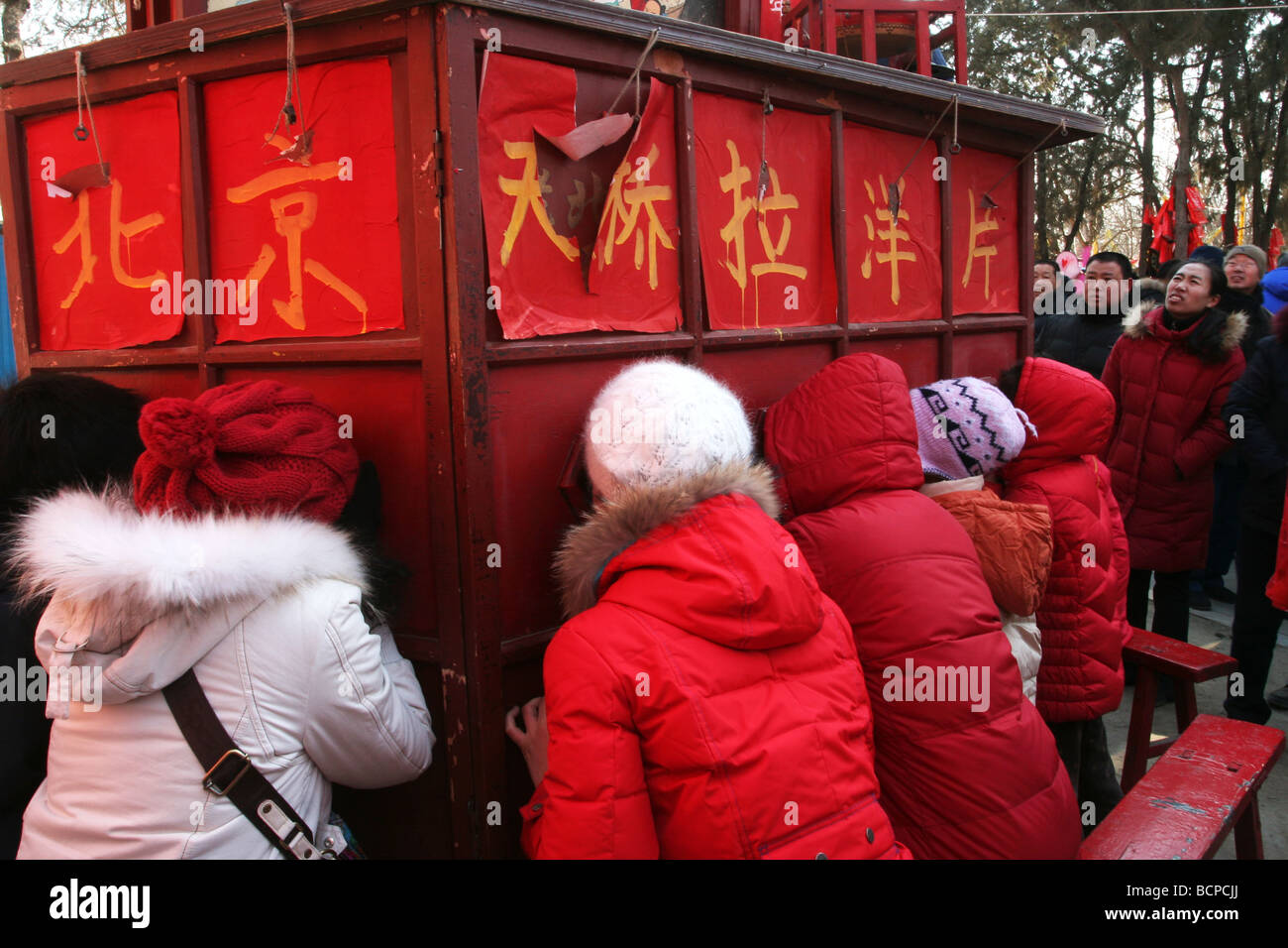 Les touristes regardant peep show traditionnel, Tiao Branch, Beijing, Chine Banque D'Images