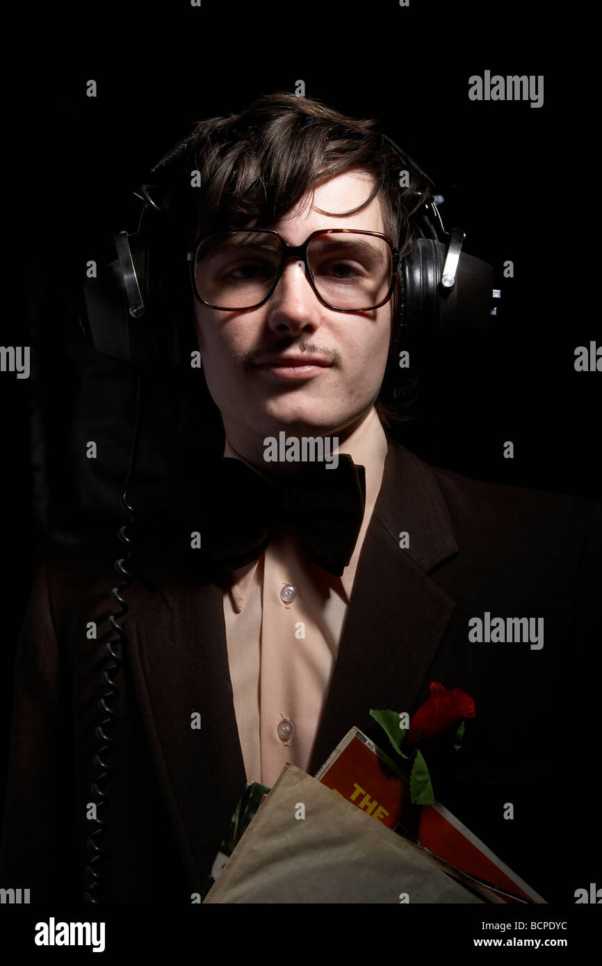 Portrait d'homme avec style années 70 costume avec records et écouteurs Banque D'Images