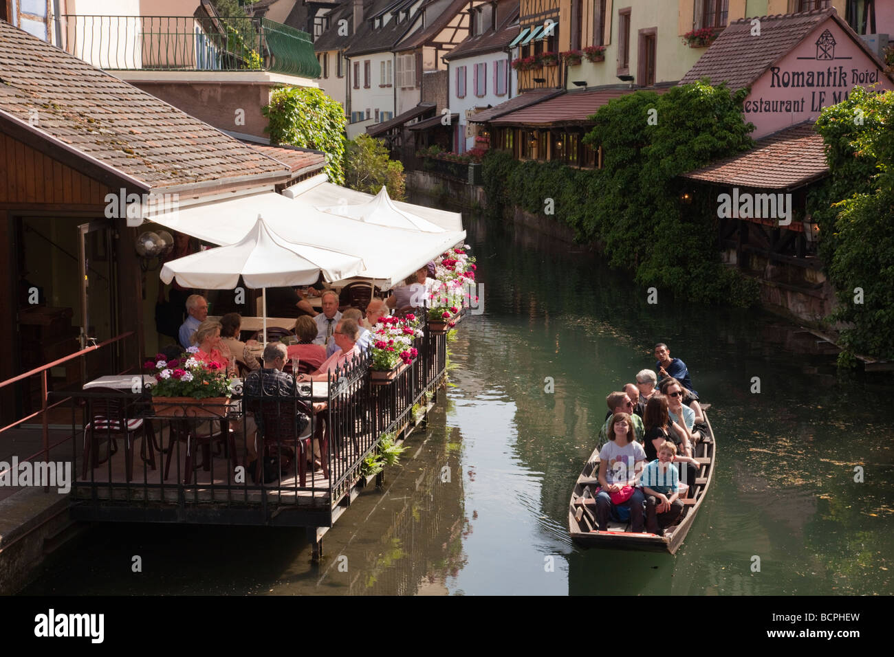 'La Petite Venise' Colmar Haut-Rhin Alsace France restaurant au bord du canal et les touristes en bateau, visite de la vieille ville Banque D'Images