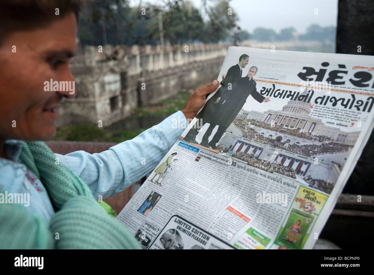 Man reading Gujarati histoire de journal de Barack Obama inauguration présidentielle américaine Bhavnagar Inde Banque D'Images